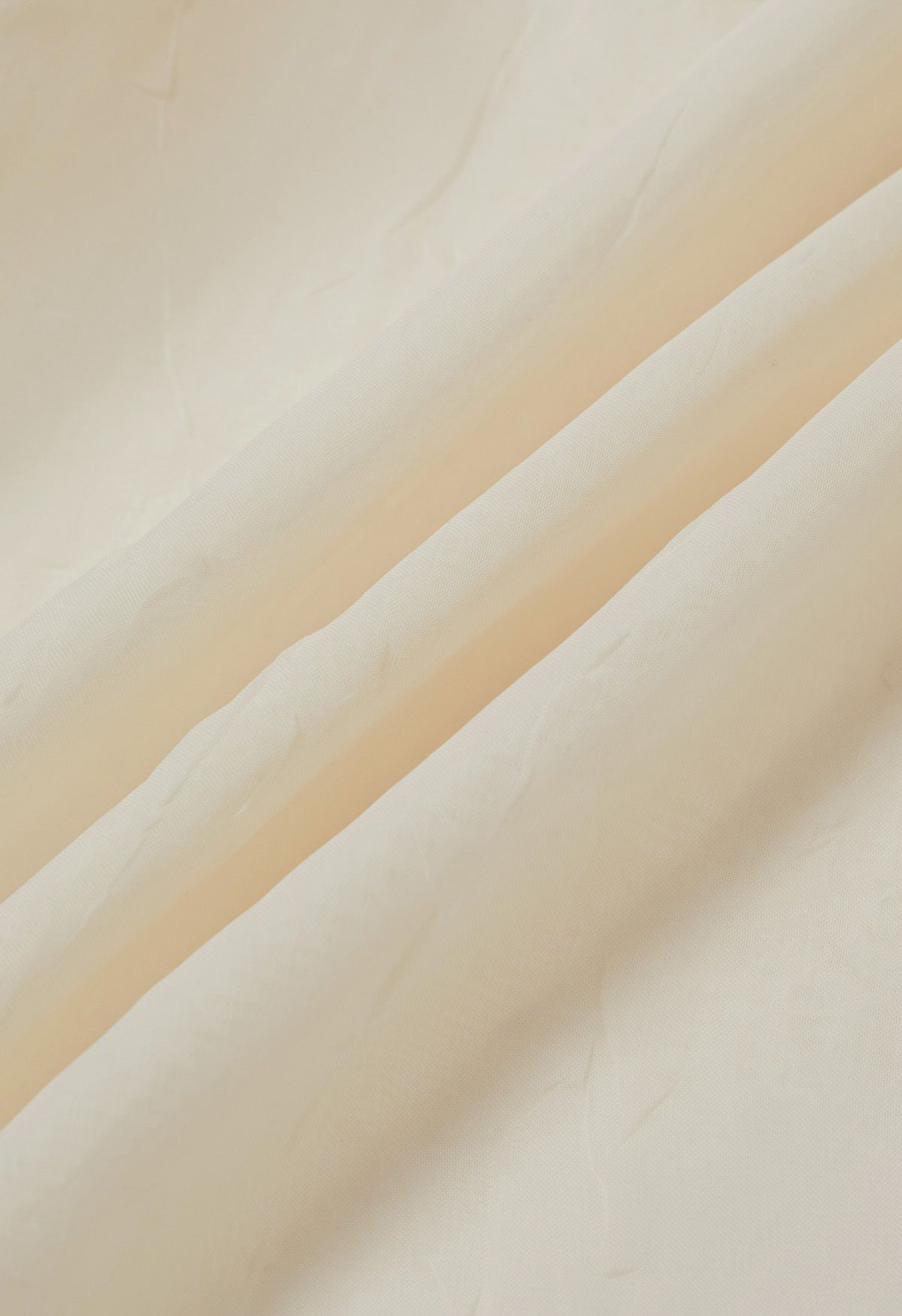 Haut transparent texturé à manches bouffantes et broche rose en crème