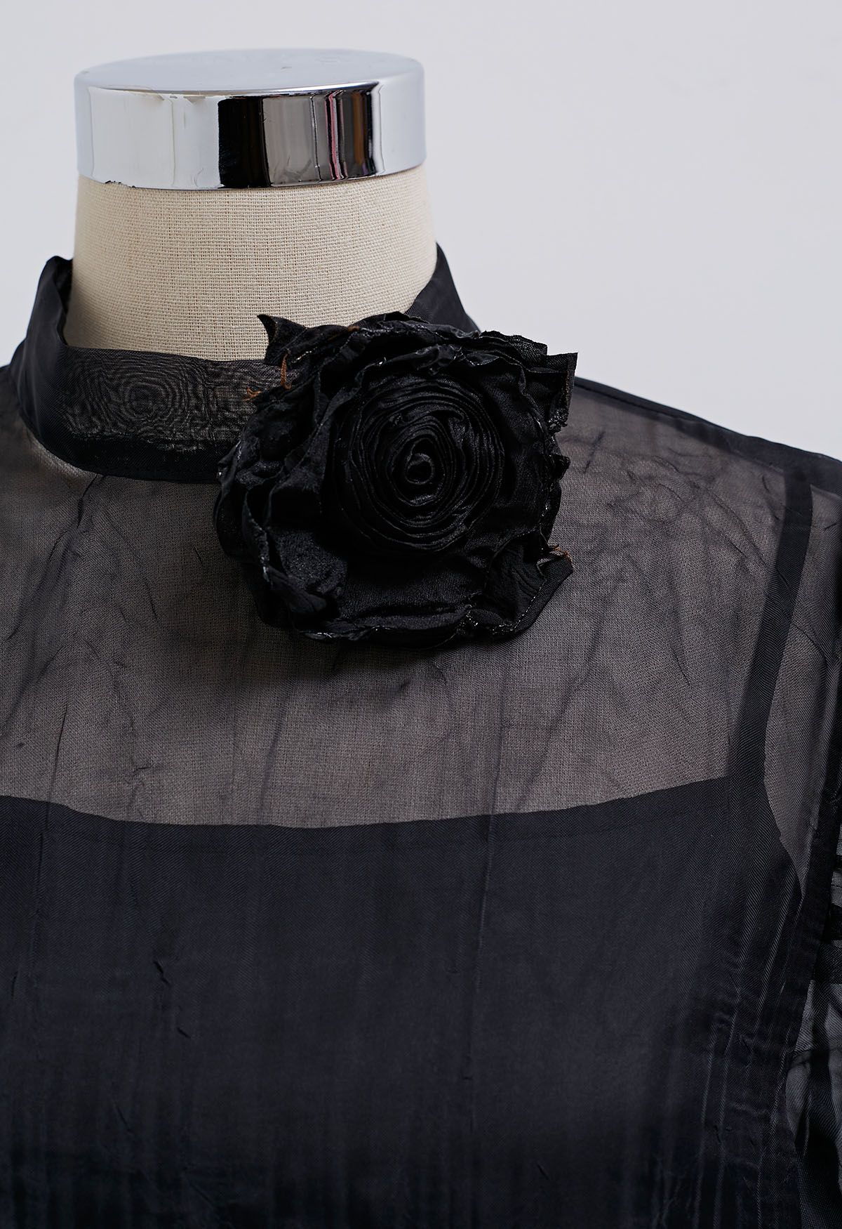 Haut transparent texturé à manches bouffantes et broche rose en noir
