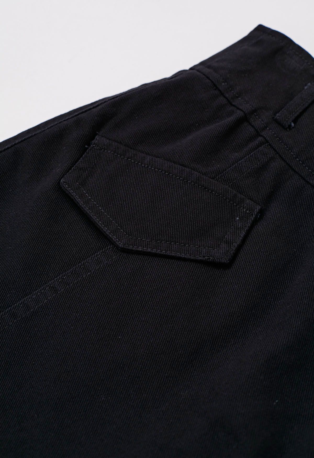 Jupe-short en jean avec fausses poches à rabat et ceinture en noir