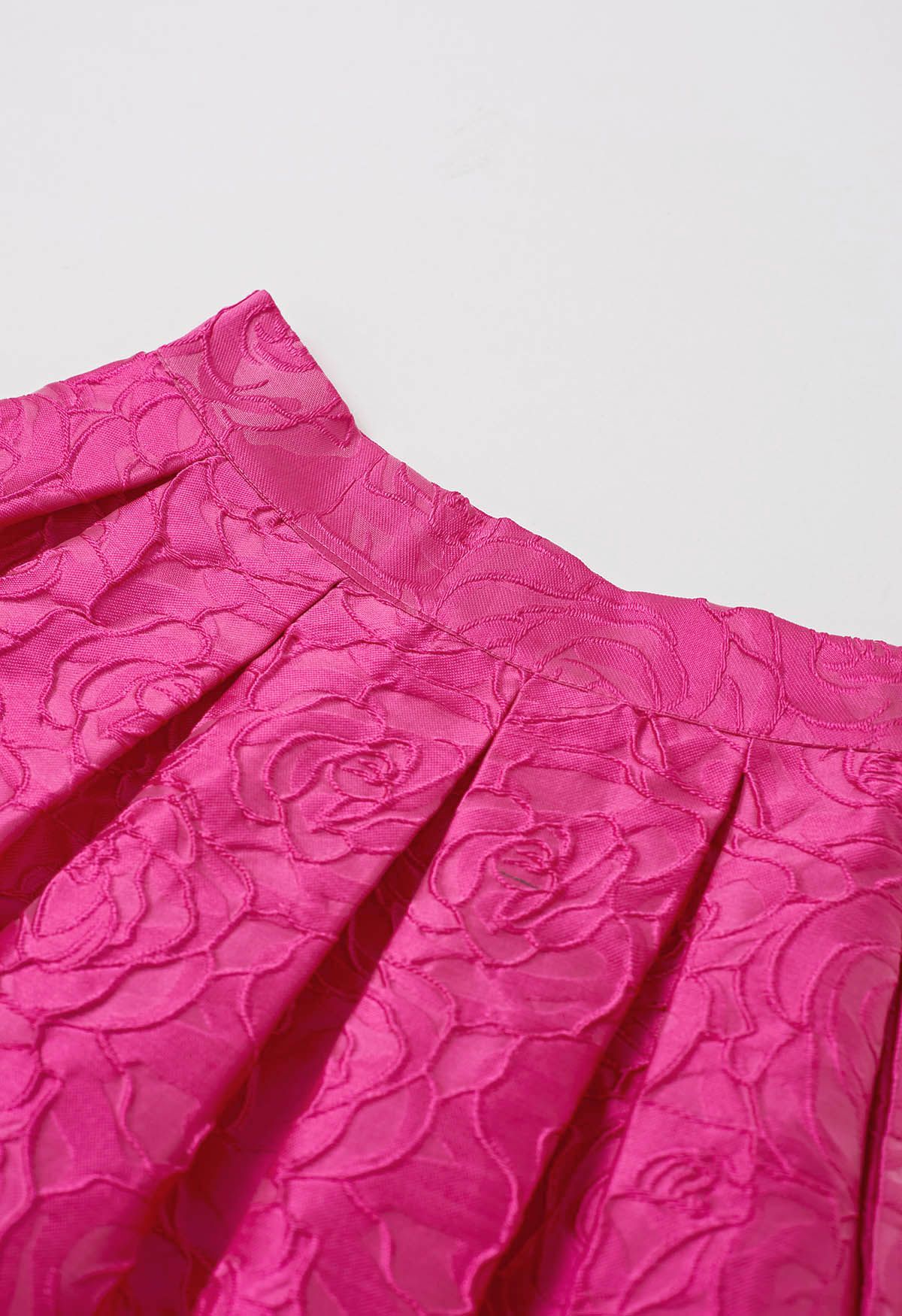 Jupe mi-longue plissée en jacquard à roses fuchsia avec poche latérale