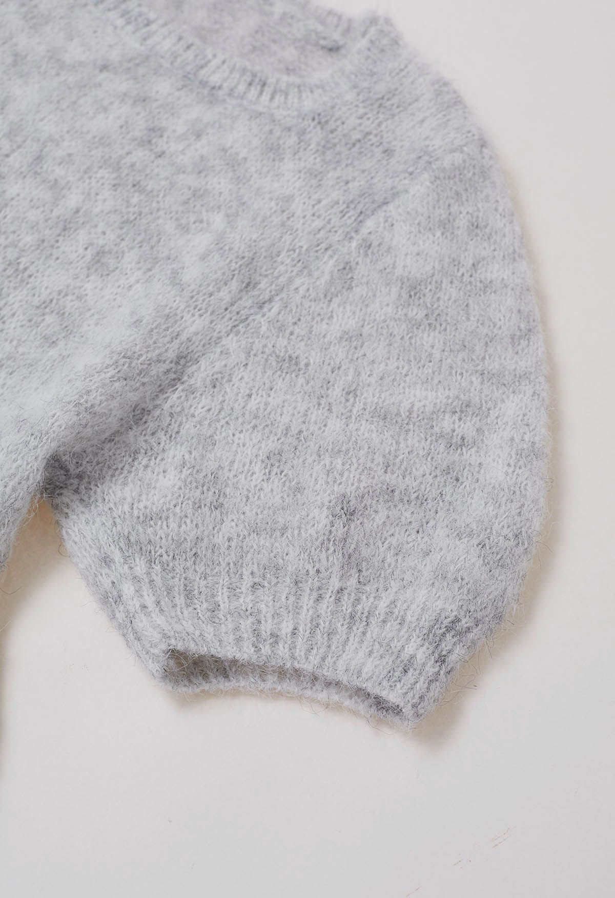 Haut en tricot pelucheux à motif péplum évasé en gris