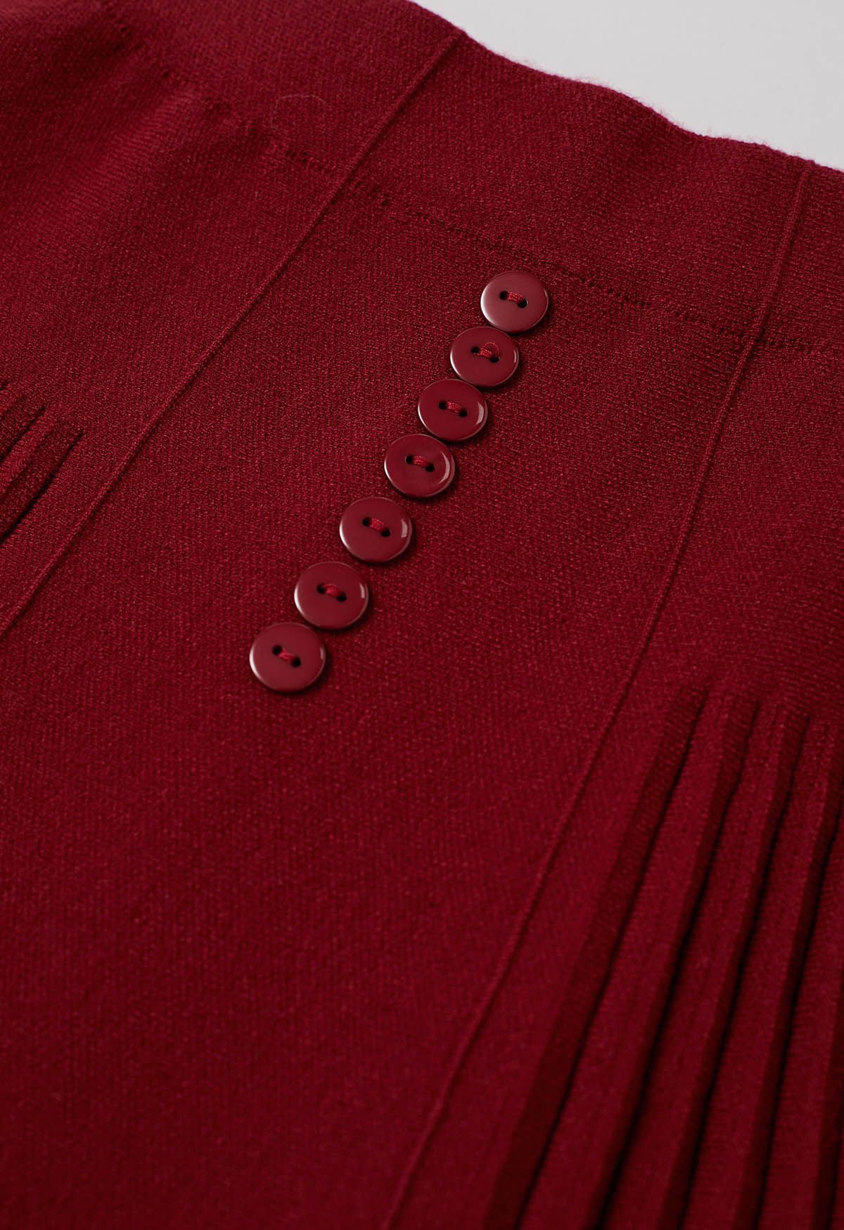 Mini-jupe en tricot à plis raffinés et bordure boutonnée en rouge