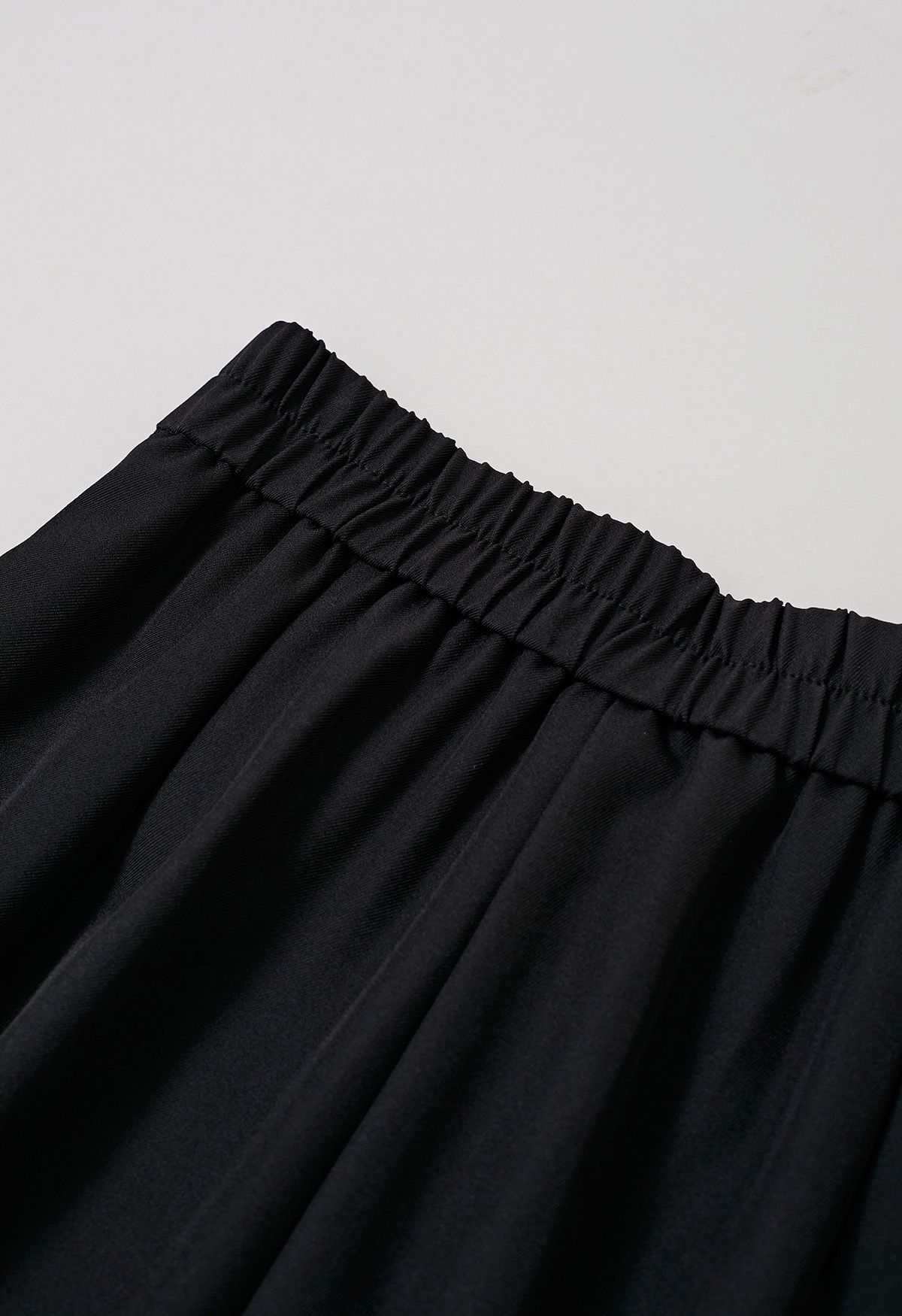 Pantalon coupe droite à boutons et à rabat asymétrique en noir