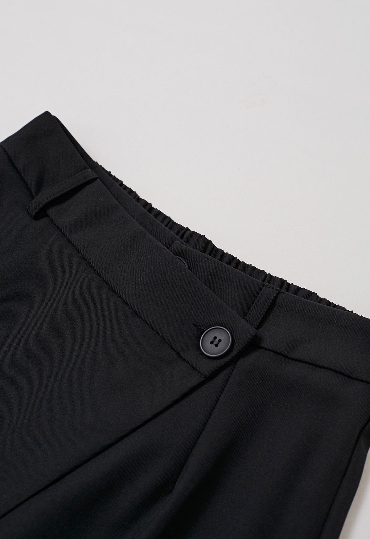 Pantalon coupe droite à boutons et à rabat asymétrique en noir