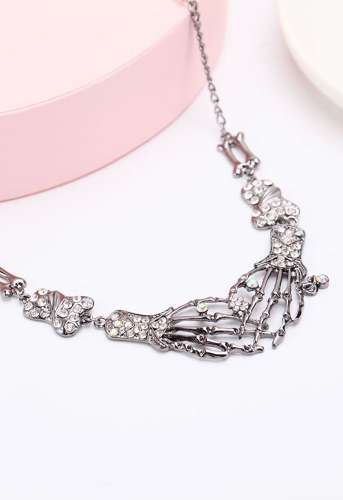 Collier en strass avec main de squelette