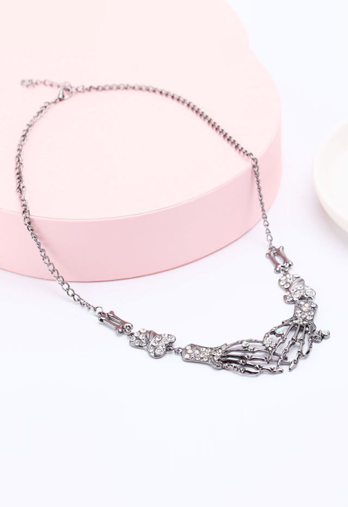 Collier en strass avec main de squelette