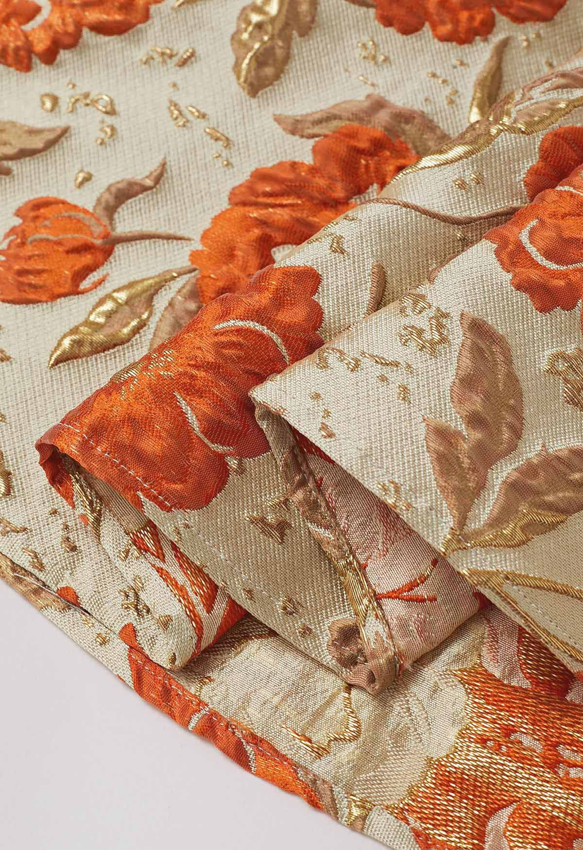 Jupe mi-longue plissée évasée en jacquard fleuri orné de motifs orange