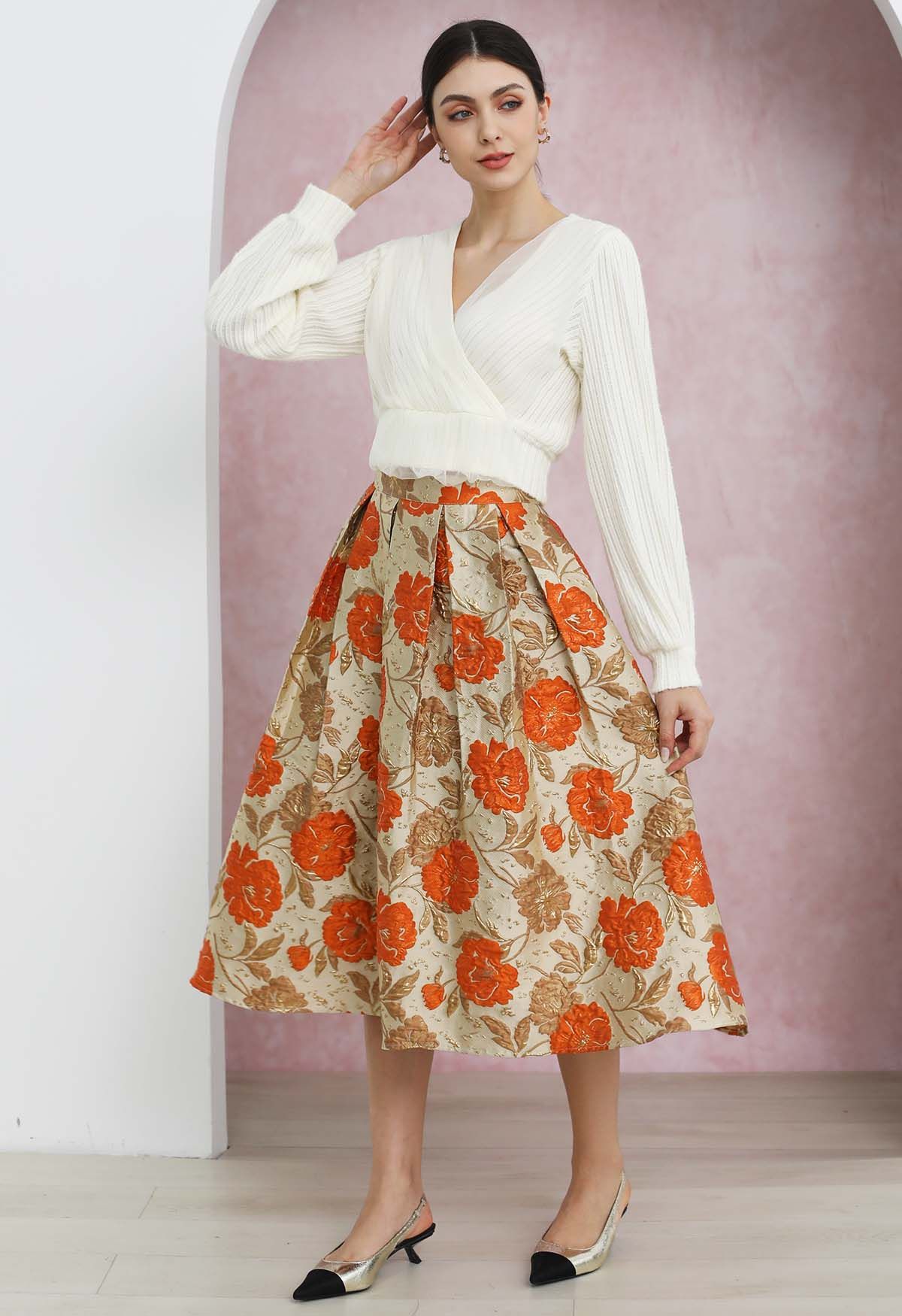 Jupe mi-longue plissée évasée en jacquard fleuri orné de motifs orange