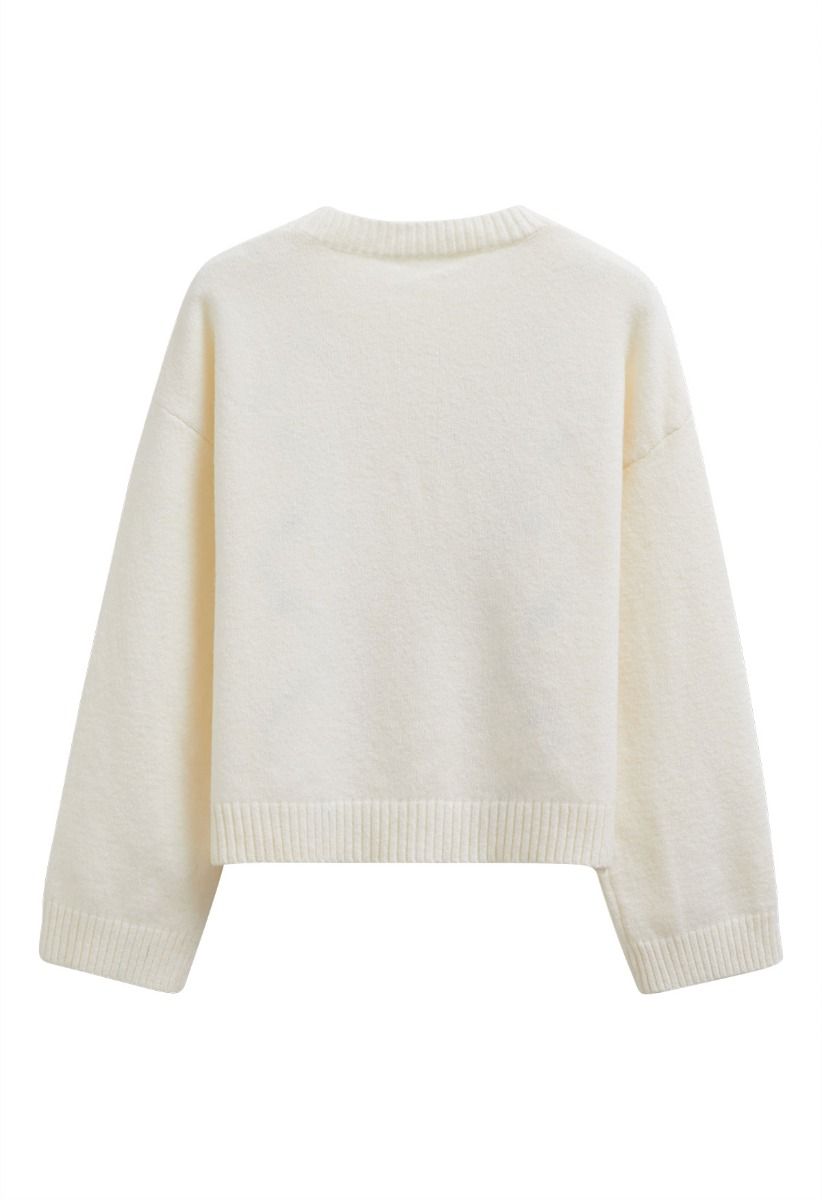 Pull côtelé à pompons et à motifs floraux en losanges, couleur crème