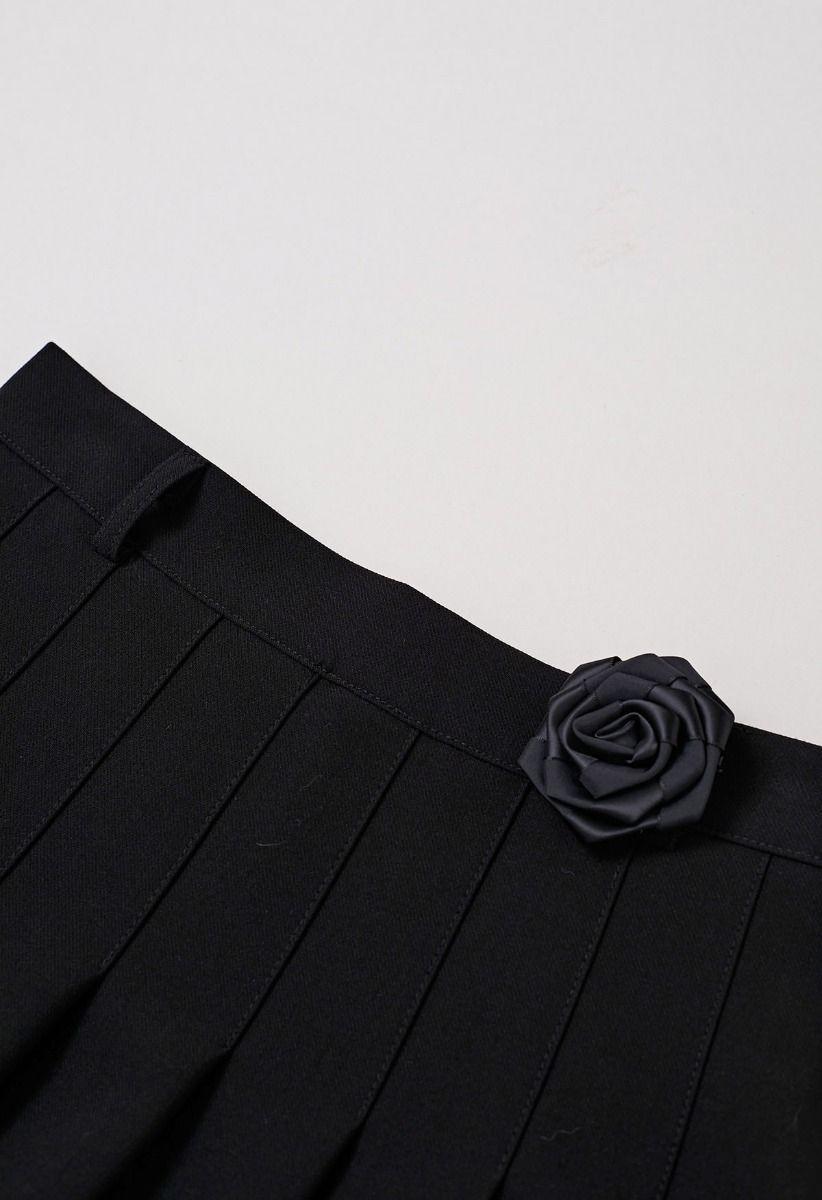 Mini-jupe plissée avec ceinture en chaîne et broche rose en noir