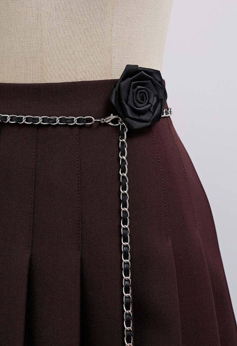 Mini-jupe plissée avec ceinture en chaîne et broche rose en bordeaux