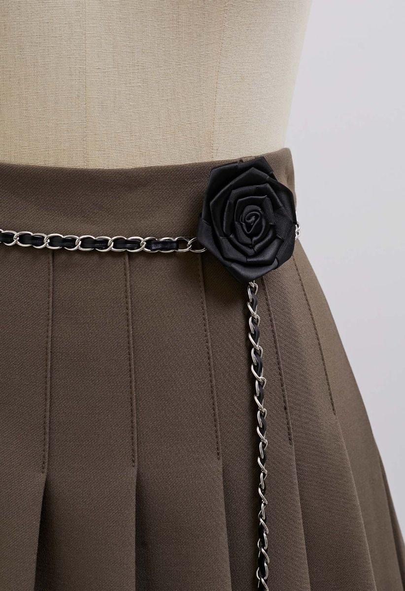 Mini-jupe plissée avec ceinture en chaîne et broche rose en marron