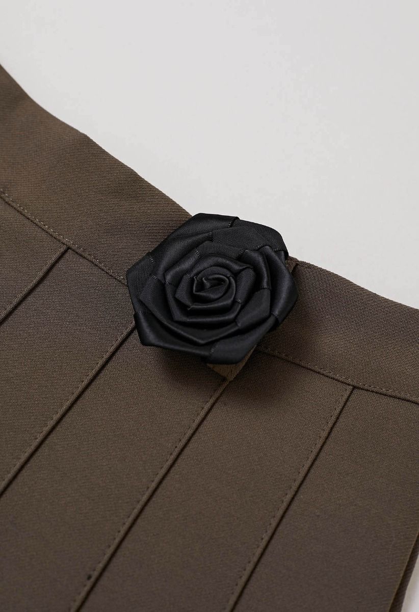 Mini-jupe plissée avec ceinture en chaîne et broche rose en marron