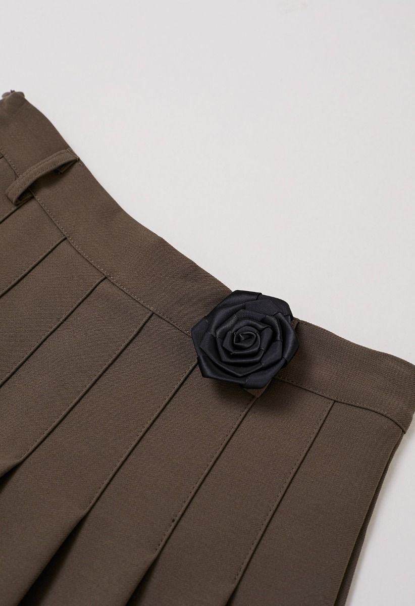 Mini-jupe plissée avec ceinture en chaîne et broche rose en marron