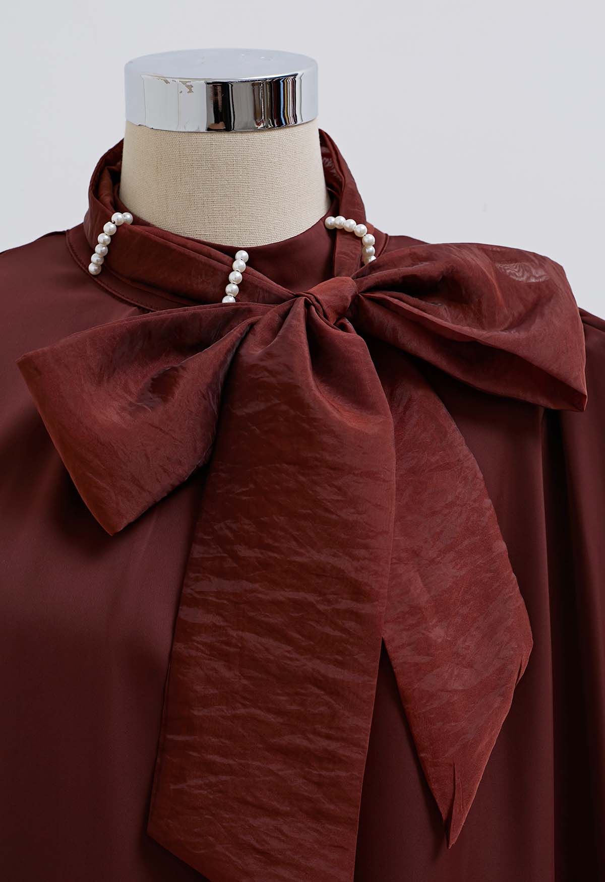 Haut en satin bordeaux avec nœud sur le côté et décolleté en perles