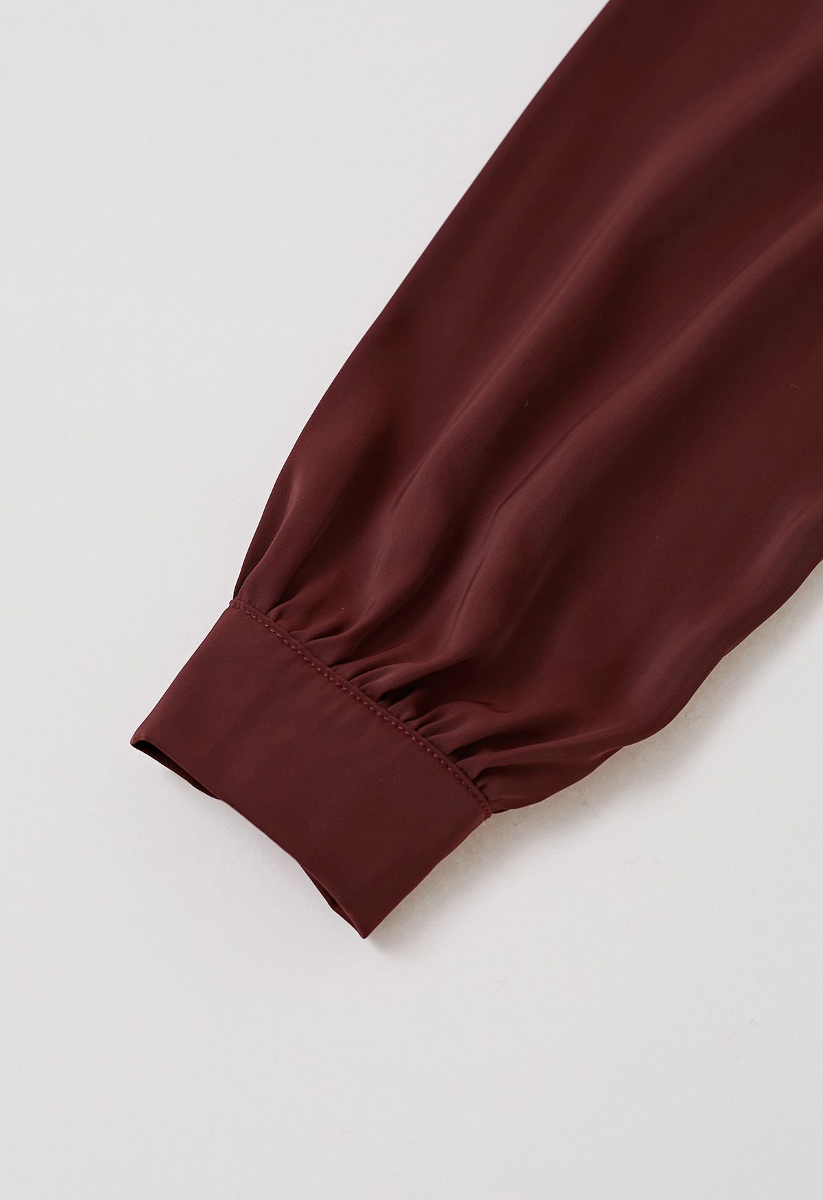 Haut en satin bordeaux avec nœud sur le côté et décolleté en perles