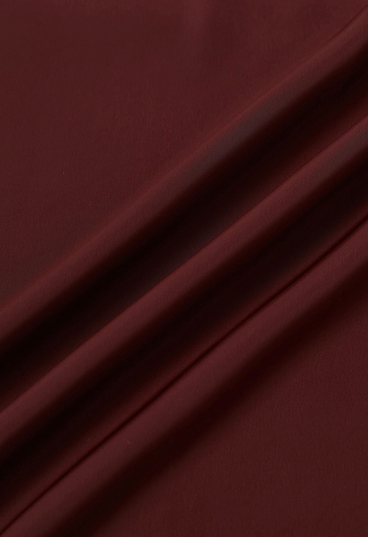 Haut en satin bordeaux avec nœud sur le côté et décolleté en perles