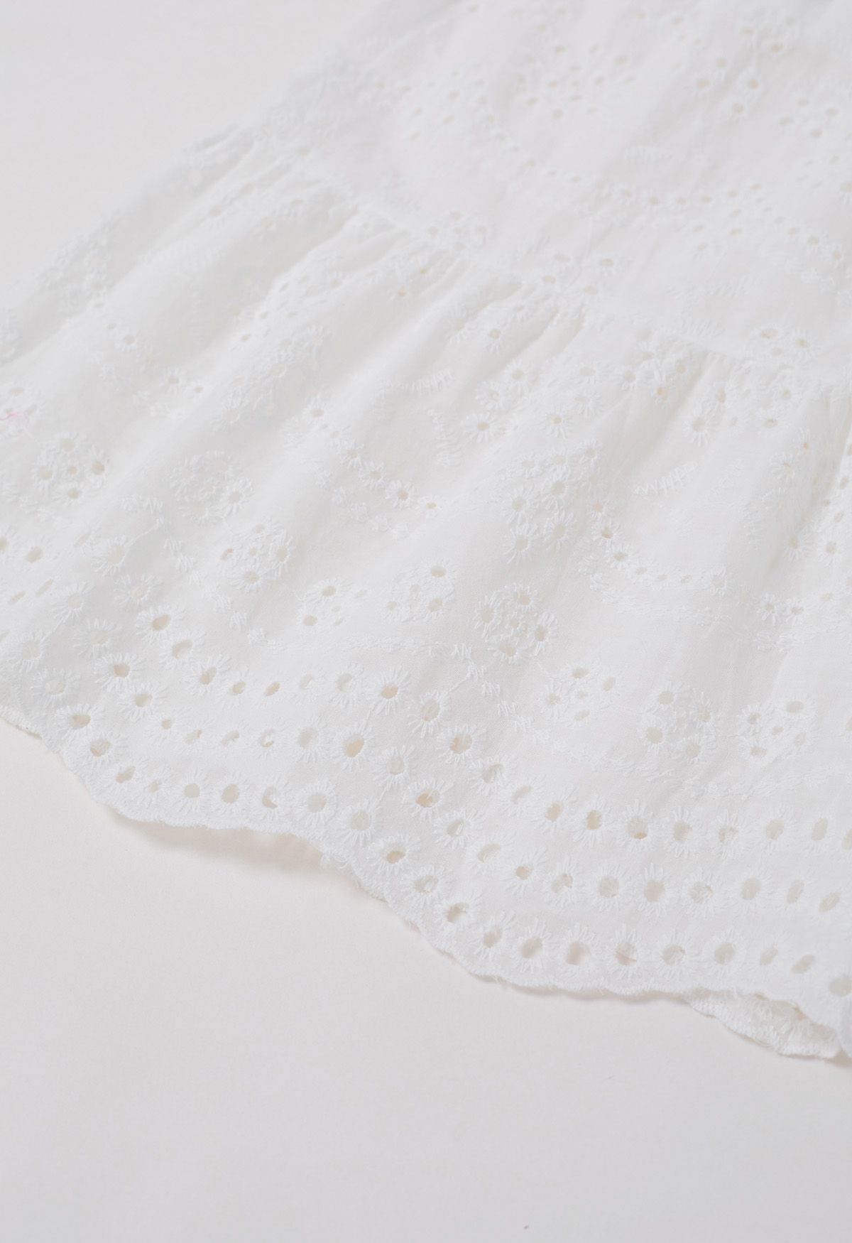 Robe mi-longue boutonnée à taille nouée et broderie délicate à œillets en blanc