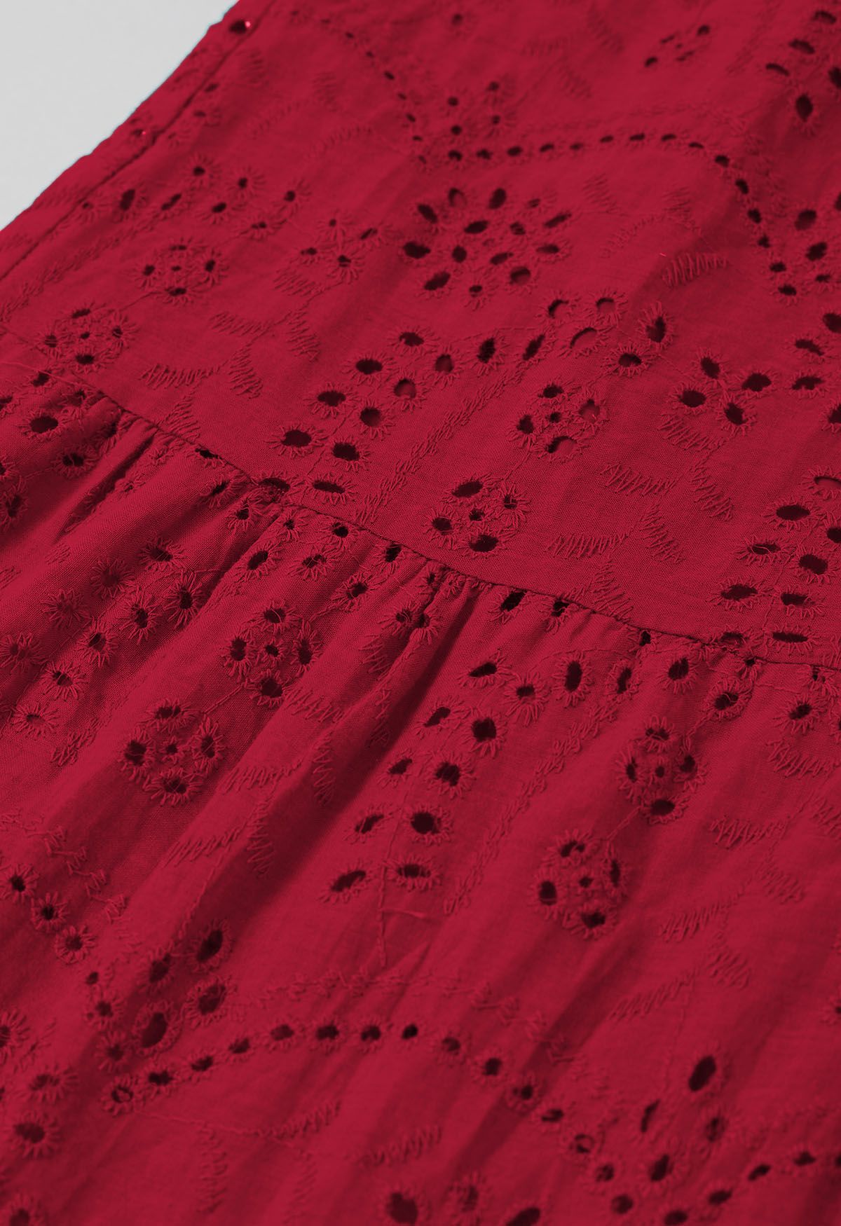 Robe mi-longue boutonnée à taille nouée et broderie délicate à œillets en rouge