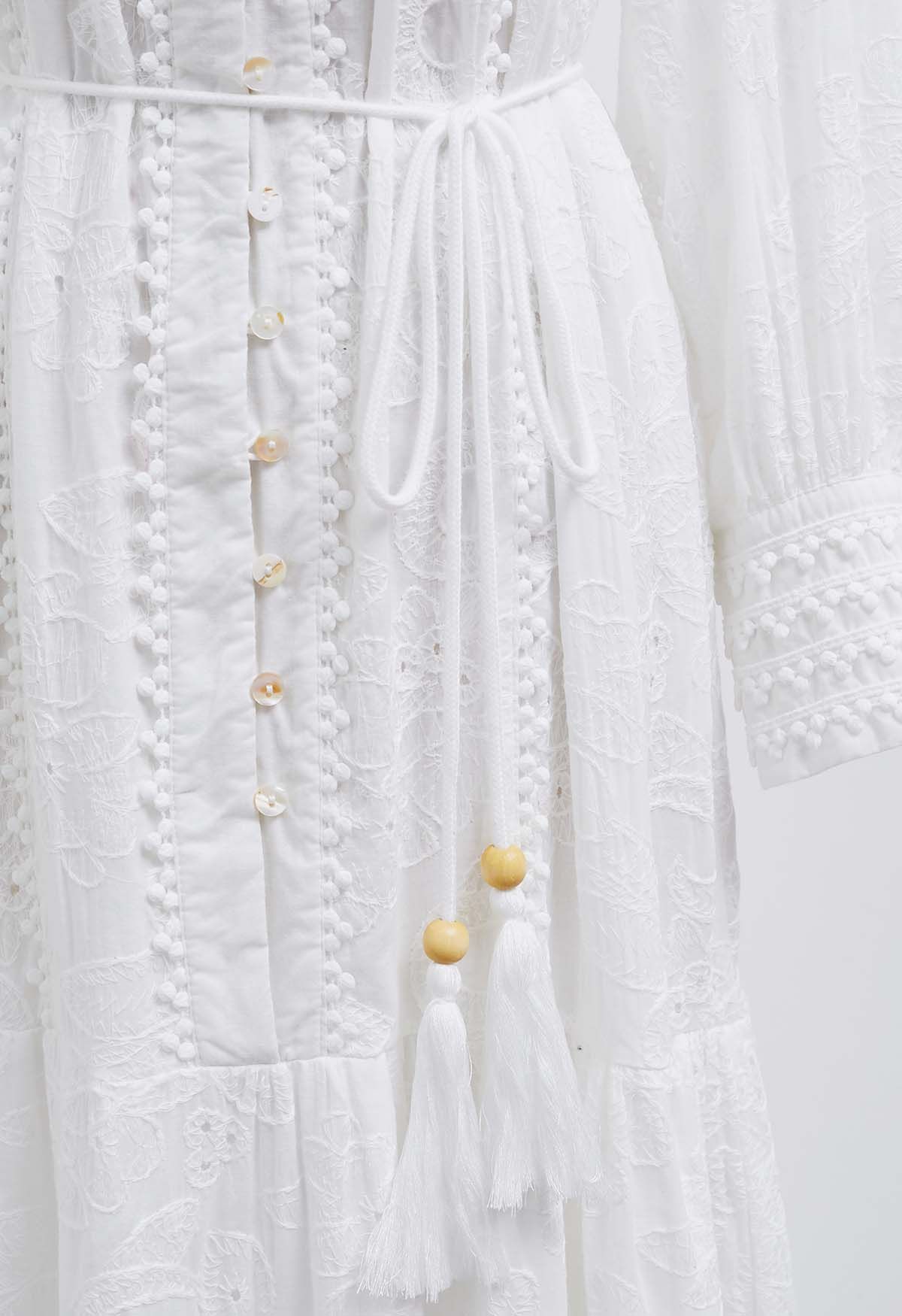 Robe longue boutonnée à pompons et broderies florales en blanc