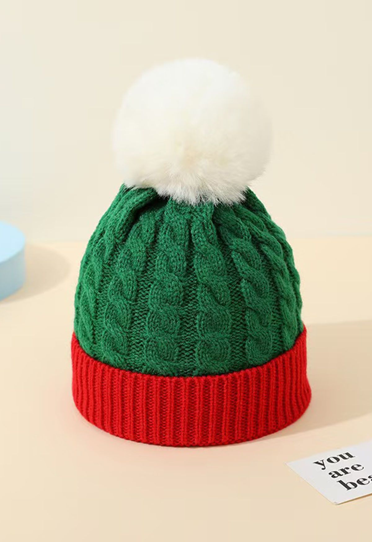 Bonnet en tricot tressé à pompon duveteux en vert