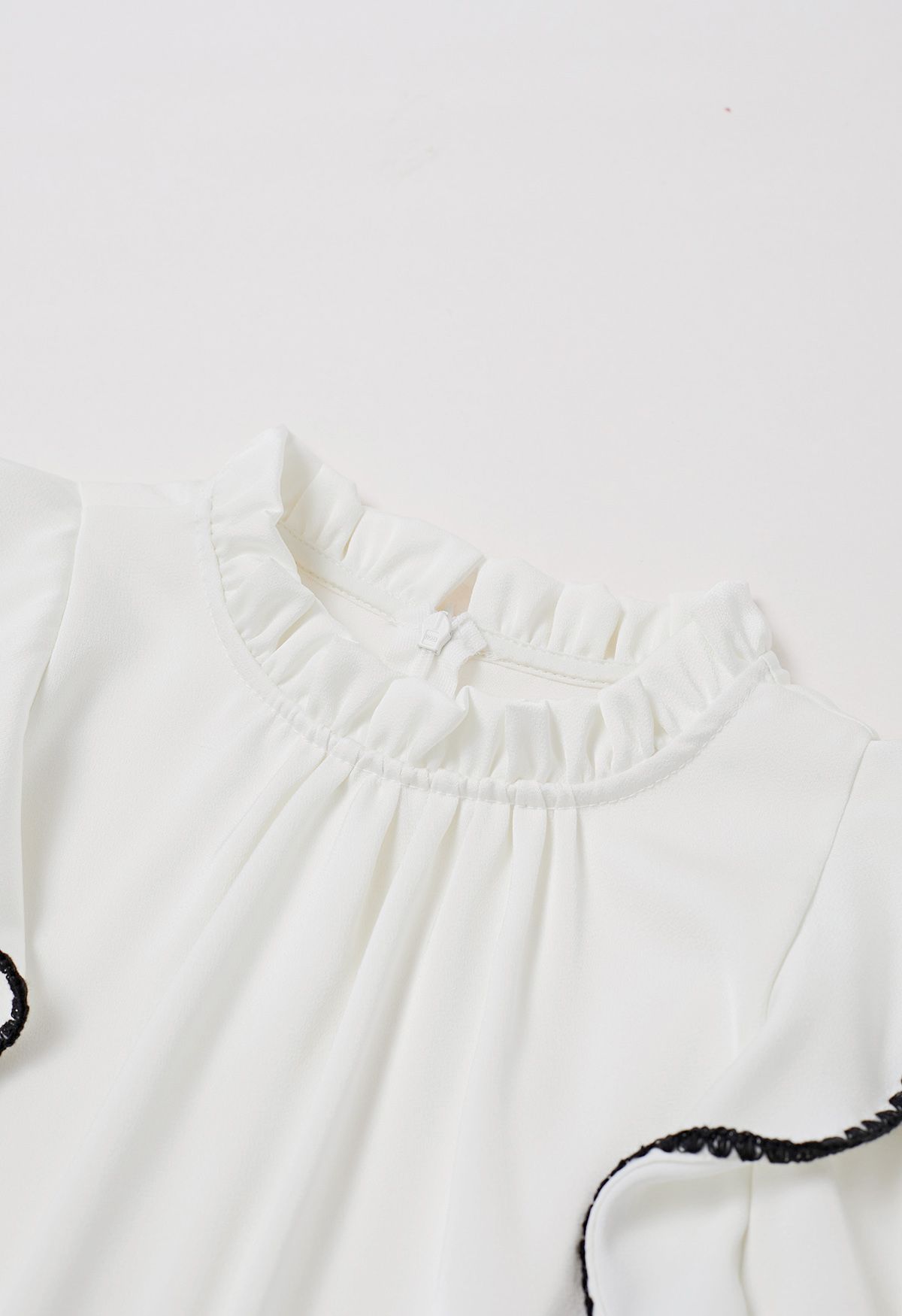 Chemise à manches bouffantes et volants à surpiqûres noires en blanc