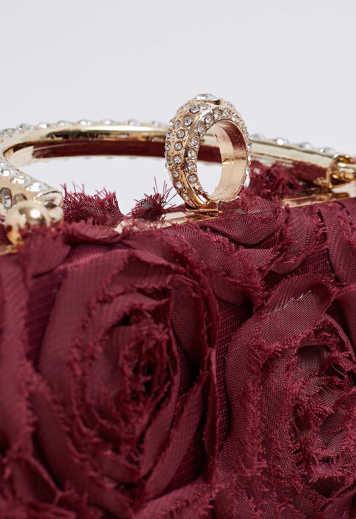 Pochette opulente avec poignée en strass rose en bordeaux