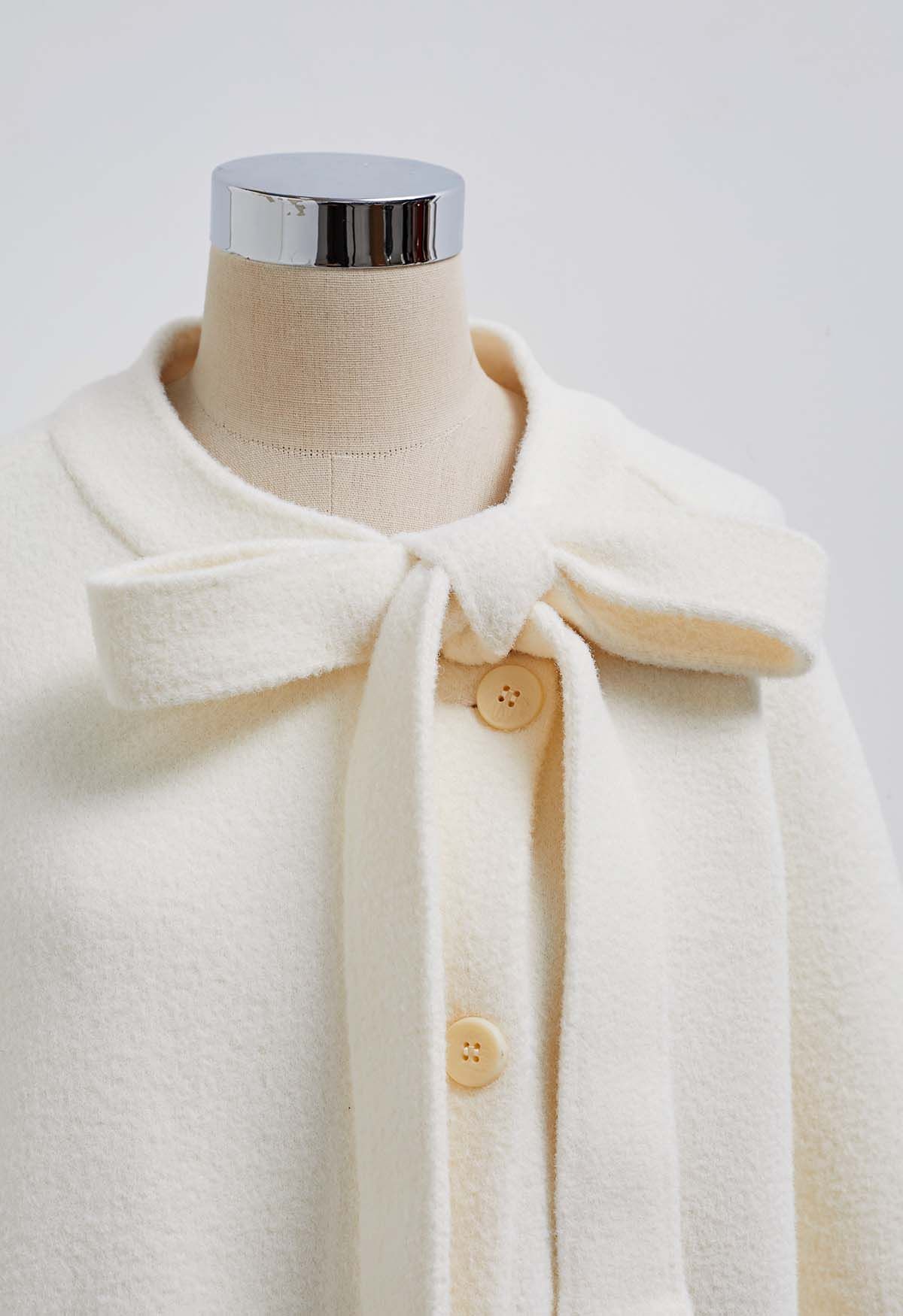 Joli manteau boutonné en tricot avec fausse fourrure et nœud papillon en ivoire