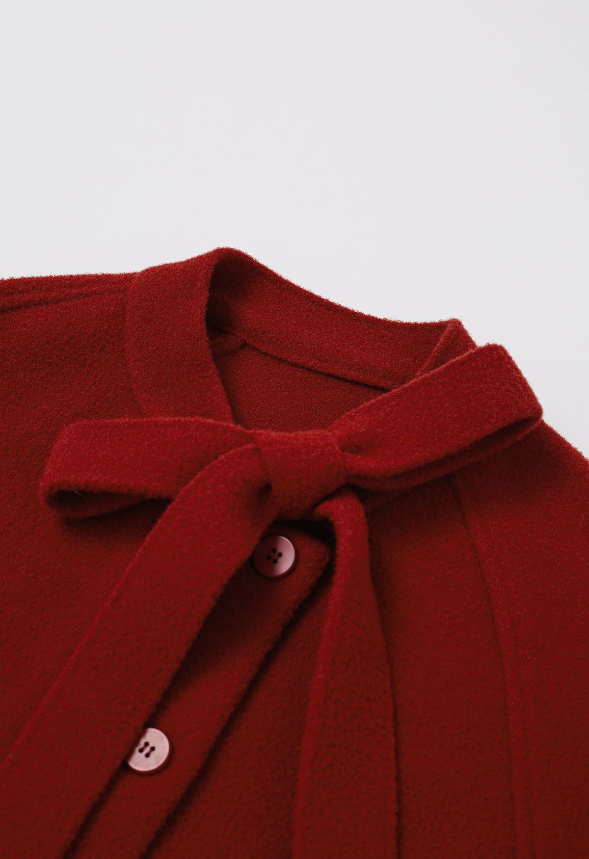 Joli manteau en tricot boutonné en fausse fourrure avec nœud papillon en rouge