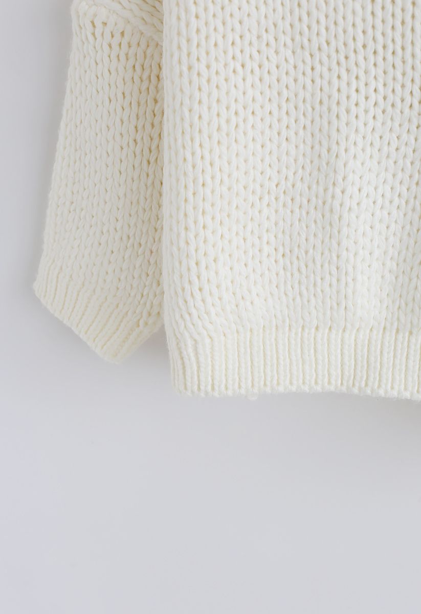 L'autre côté du gros pull tricoté à la main en blanc