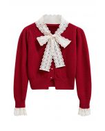 Cardigan en tricot pelucheux avec œillets brodés, nœud papillon et bouton cœur en rouge