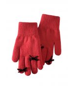 Gants en tricot avec trou pour les doigts et décoration avec nœud papillon en rouge