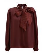 Haut en satin bordeaux avec nœud sur le côté et décolleté en perles