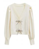 Cardigan en tricot boutonné à manches lanternes et nœud papillon scintillant en crème